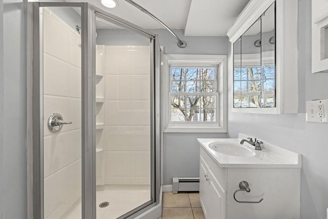 bathroom with tile patterned floors, baseboard heating, a stall shower, and vanity