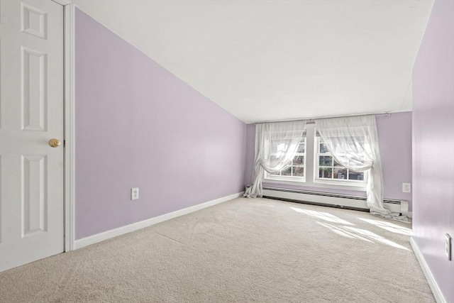 empty room featuring a baseboard radiator, baseboards, carpet, and lofted ceiling