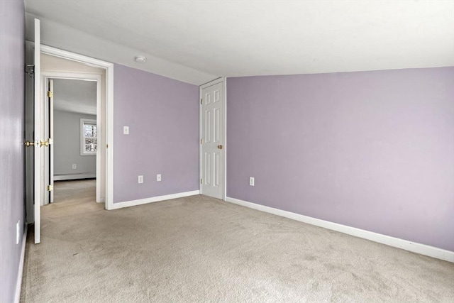 unfurnished bedroom with baseboard heating, baseboards, lofted ceiling, and carpet