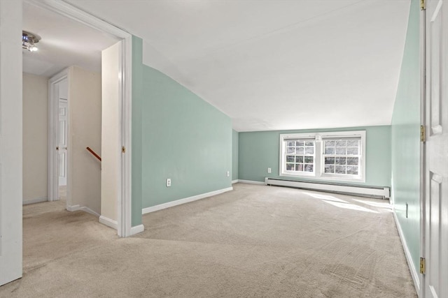 unfurnished living room featuring baseboards, baseboard heating, lofted ceiling, and carpet flooring