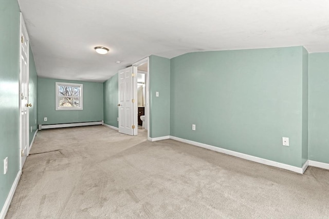 empty room with lofted ceiling, baseboards, carpet floors, and a baseboard radiator