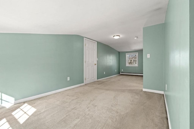 empty room with lofted ceiling, baseboards, baseboard heating, and light carpet