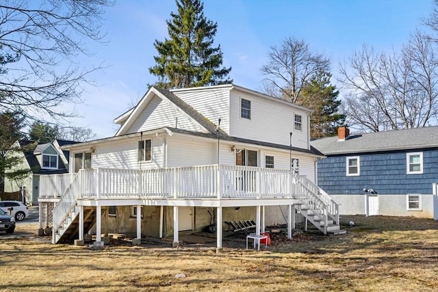 rear view of property featuring stairway and a deck