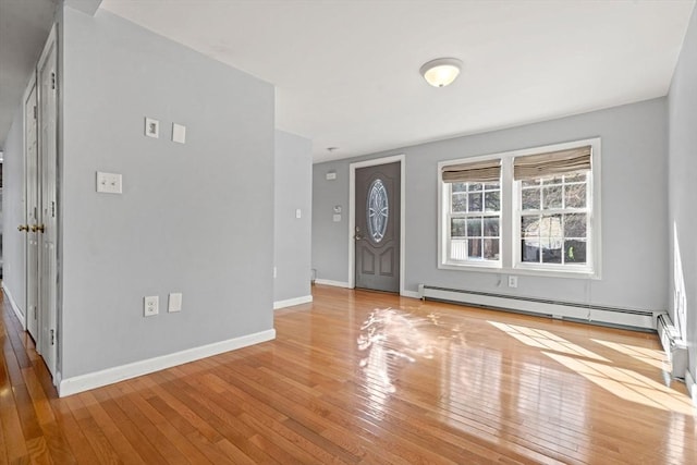 foyer with baseboards, wood-type flooring, and a baseboard radiator