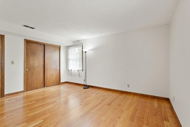 82 Neponset St Unit E, Canton, MA 02021 - unfurnished bedroom featuring light wood-type flooring, a closet, and baseboards