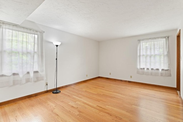 82 Neponset St Unit E, Canton, MA 02021 - empty room featuring light wood finished floors, plenty of natural light, baseboards, and a textured ceiling