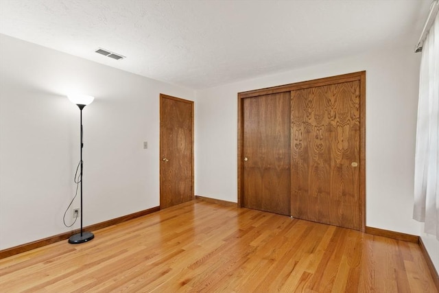 82 Neponset St Unit E, Canton, MA 02021 - unfurnished bedroom with light wood-type flooring, baseboards, and a closet