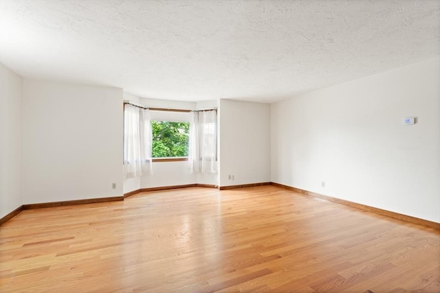 82 Neponset St Unit E, Canton, MA 02021 - spare room with light wood-style floors, baseboards, and a textured ceiling