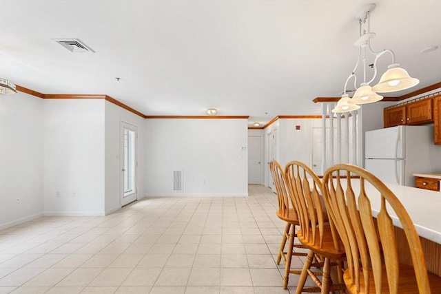 dining area with baseboards, ornamental molding, and visible vents