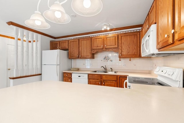 kitchen with white appliances, light countertops, brown cabinetry, decorative backsplash, and a sink