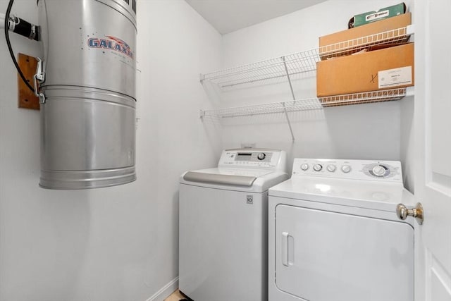 washroom featuring independent washer and dryer, laundry area, and baseboards