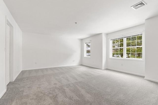 carpeted spare room with baseboards and visible vents