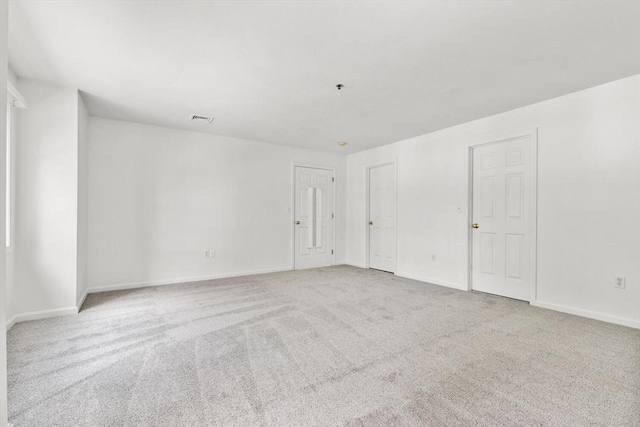 empty room with visible vents, baseboards, and carpet