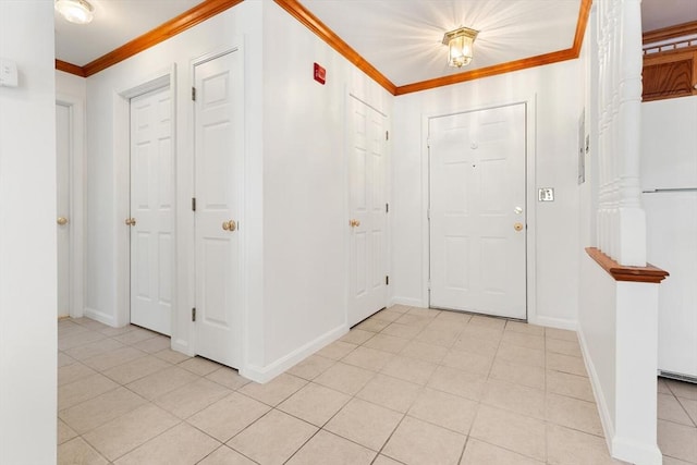 foyer entrance with baseboards, ornamental molding, and light tile patterned flooring