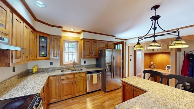 56-58 E Bacon St, Plainville, MA 02762 - kitchen with stainless steel appliances, a sink, under cabinet range hood, crown molding, and brown cabinetry