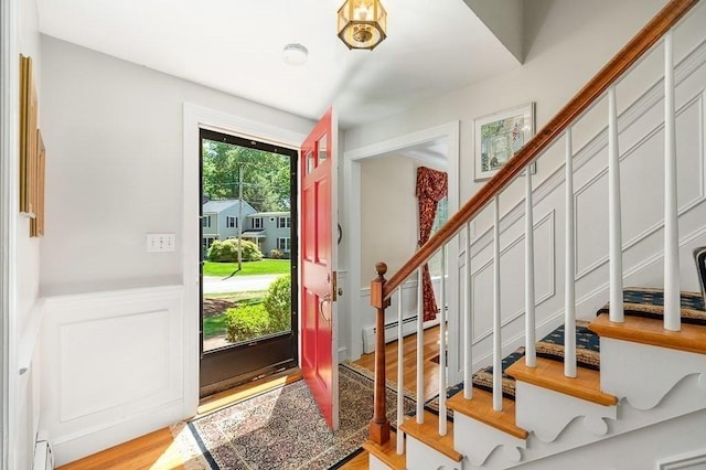 3 Tally Ho Dr, Hamilton, MA 01982 - entryway with stairs, wood finished floors, a wainscoted wall, baseboard heating, and a baseboard heating unit