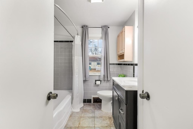 full bathroom with toilet, vanity, tile walls, tile patterned floors, and shower / bath combination with curtain