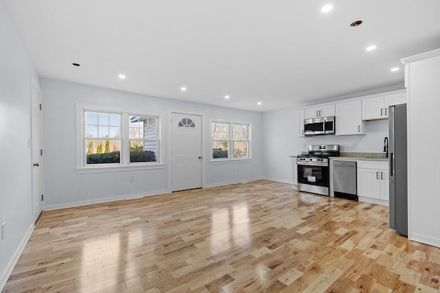 kitchen featuring light wood-style floors, light countertops, white cabinets, a sink, and stainless steel appliances