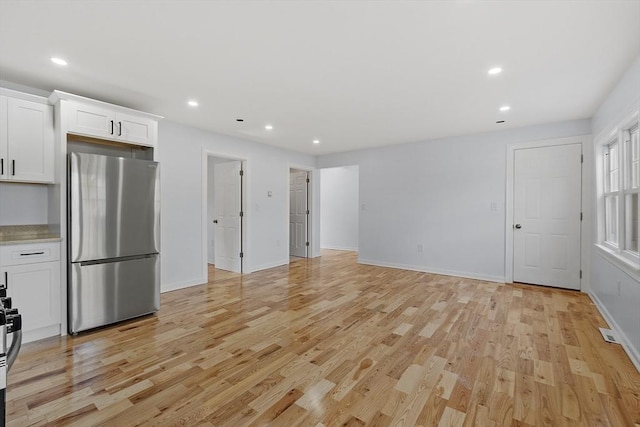 kitchen featuring freestanding refrigerator, recessed lighting, light wood-style flooring, and white cabinetry