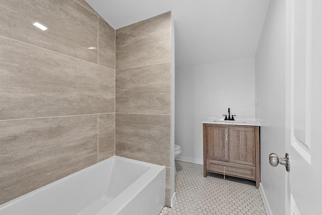 bathroom featuring a tub, toilet, baseboards, and vanity