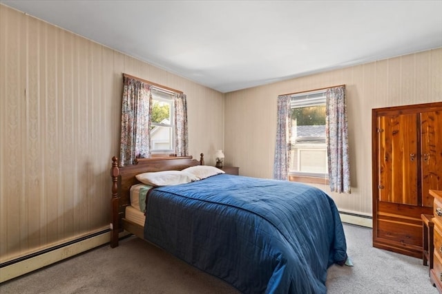 carpeted bedroom featuring baseboard heating and multiple windows