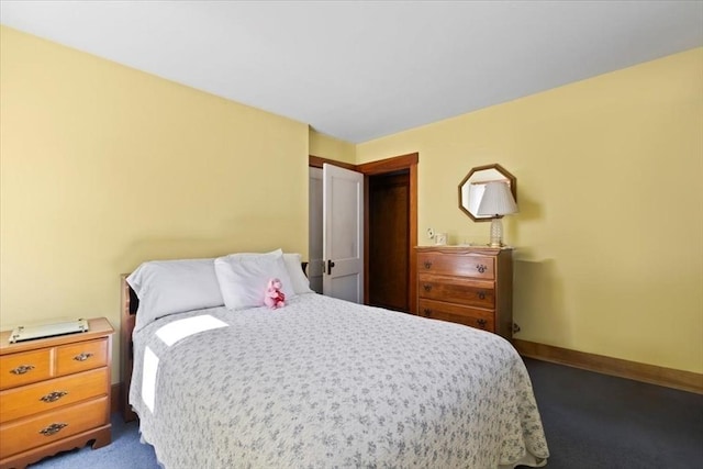 bedroom with baseboards and dark colored carpet