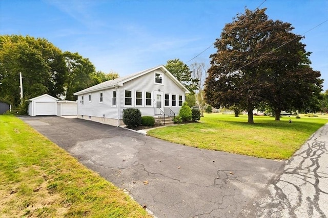 bungalow-style house with a garage, a front yard, an outdoor structure, and entry steps