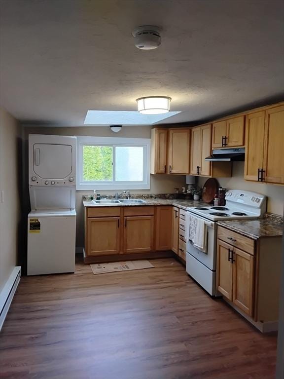kitchen with under cabinet range hood, white range with electric stovetop, a sink, light wood finished floors, and stacked washer / drying machine