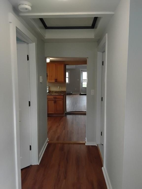 hall with dark wood-style flooring and baseboards