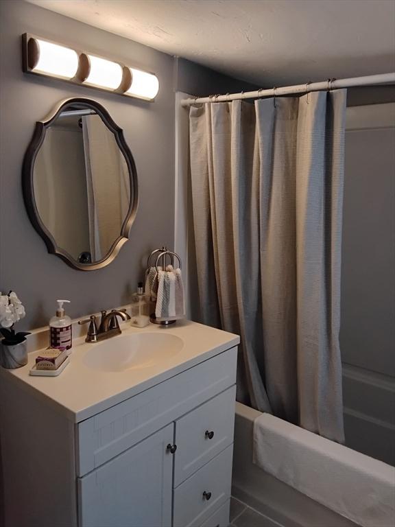 bathroom featuring vanity and shower / bath combination with curtain