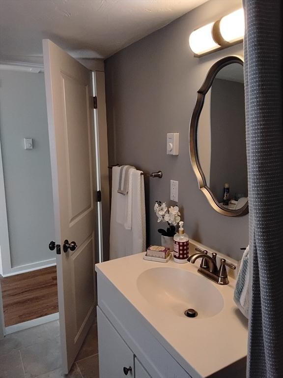 bathroom featuring vanity, baseboards, and tile patterned flooring