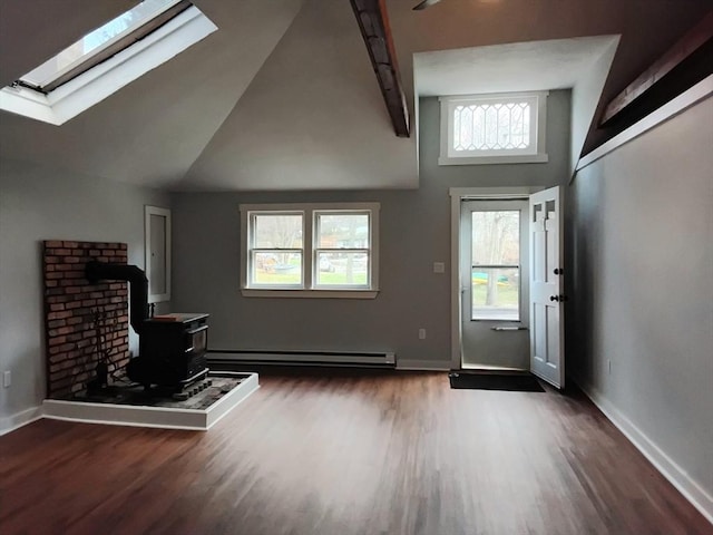 unfurnished living room featuring a wood stove, a skylight, wood finished floors, a baseboard radiator, and baseboards