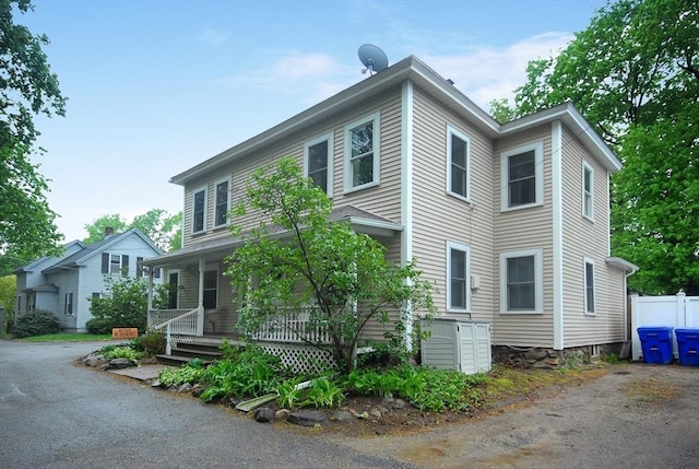 view of front of property featuring covered porch and fence