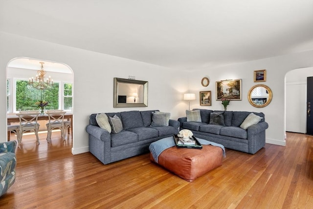 39 Manton Rd, Swampscott, MA 01907 - living area featuring arched walkways, a chandelier, light wood finished floors, and baseboards