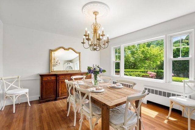 39 Manton Rd, Swampscott, MA 01907 - dining room with radiator heating unit, light wood-style flooring, and a chandelier