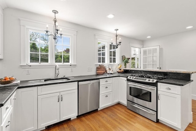 39 Manton Rd, Swampscott, MA 01907 - kitchen featuring appliances with stainless steel finishes, a chandelier, a sink, light wood-style floors, and white cabinetry