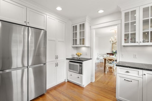 39 Manton Rd, Swampscott, MA 01907 - kitchen with appliances with stainless steel finishes, light wood finished floors, white cabinets, a chandelier, and glass insert cabinets
