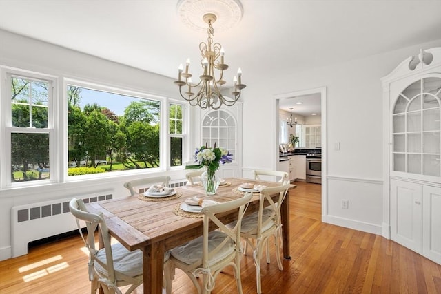 39 Manton Rd, Swampscott, MA 01907 - dining space with radiator heating unit, a chandelier, healthy amount of natural light, and light wood-type flooring