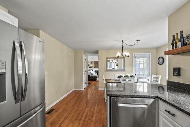 188 Munger Hill Rd, Westfield, MA 01085 - kitchen featuring stainless steel appliances, a chandelier, wood finished floors, and dark stone counters