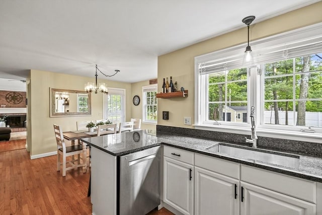 188 Munger Hill Rd, Westfield, MA 01085 - kitchen with stainless steel dishwasher, white cabinets, a sink, wood finished floors, and decorative light fixtures