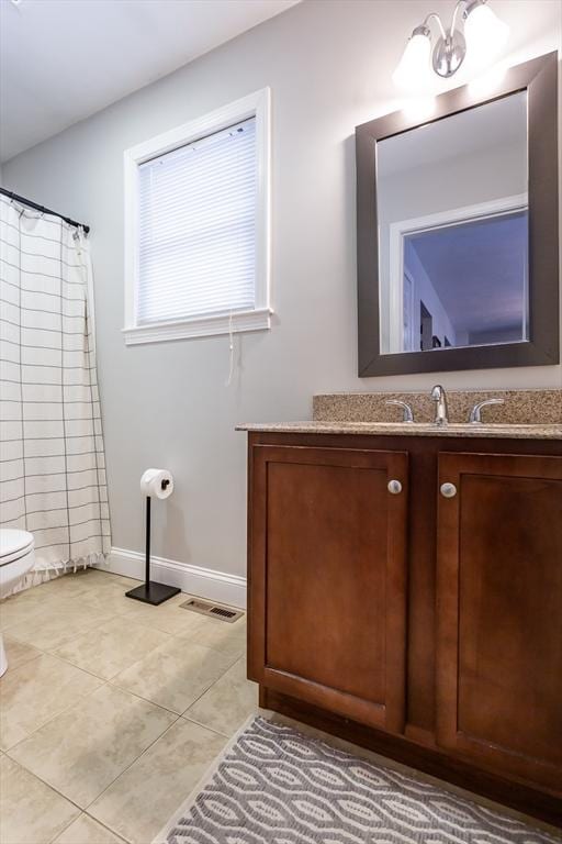 bathroom featuring tile patterned floors, vanity, and toilet