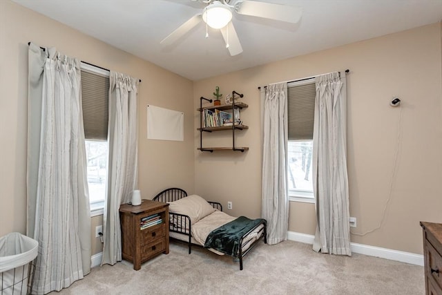 living area with light carpet and ceiling fan