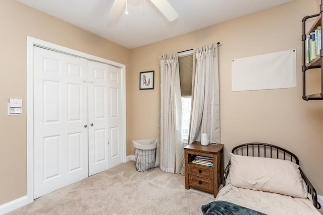 carpeted bedroom with ceiling fan and a closet