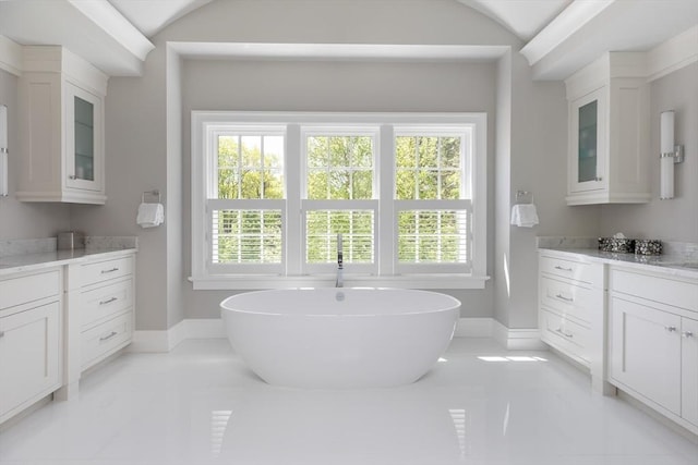 8 Hidden Rd, Weston, MA 02493 - bathroom with a freestanding tub, vanity, baseboards, lofted ceiling, and marble finish floors
