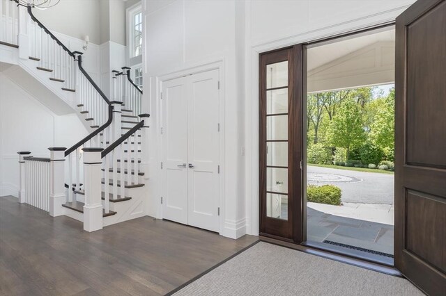 8 Hidden Rd, Weston, MA 02493 - foyer with healthy amount of natural light, wood finished floors, stairway, a towering ceiling, and baseboards