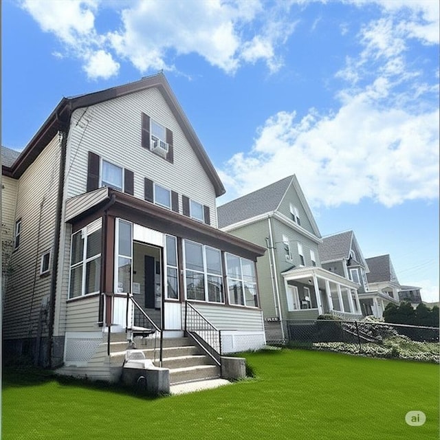 back of property featuring a lawn, entry steps, and fence