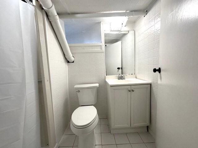 full bath featuring vanity, toilet, tile walls, and tile patterned floors
