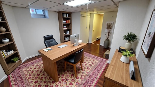 home office featuring a paneled ceiling, a baseboard radiator, and dark wood-style floors