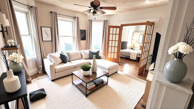 living room featuring light wood-type flooring, french doors, ceiling fan, and plenty of natural light