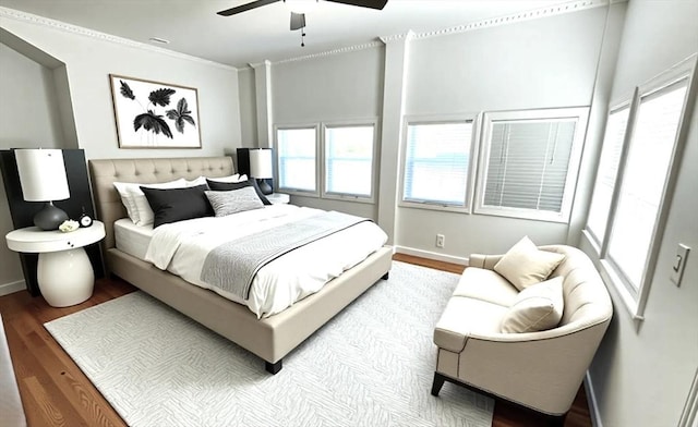 bedroom with ornamental molding, wood finished floors, baseboards, and ceiling fan
